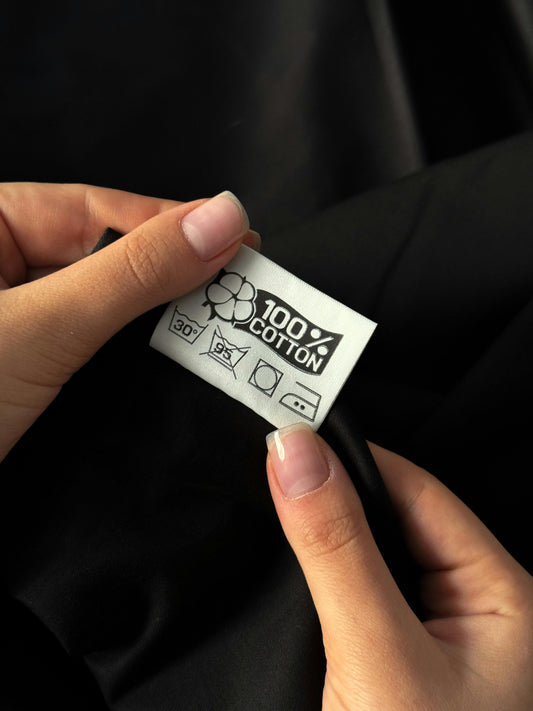 Clothing label showing 100% cotton text on fabric tag